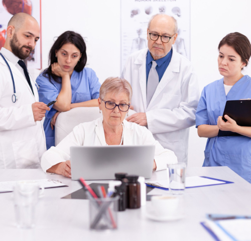 A group of doctors are gathered around a woman.